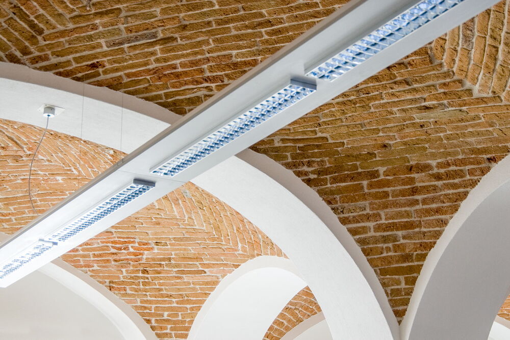 Schlichte Beleuchtungselemente im Geschäftsraum mit Gewölbe