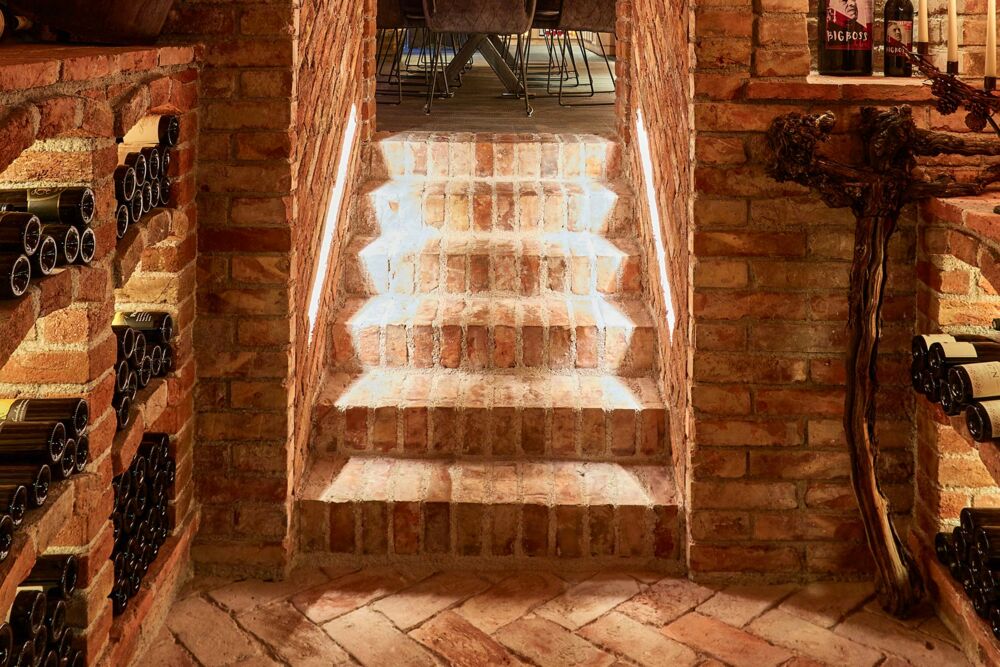 Weinkeller mit integrierten Beleuchtungselementen im Stiegenaufgang aus Ziegel gemauert