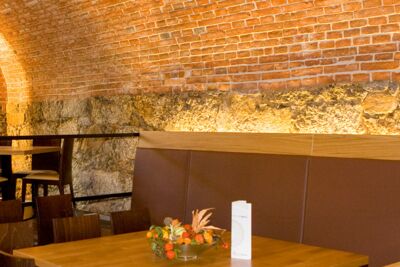 Altes Steinmauerwerk als Widerlager für großes Tonnengewölbe im Restaurant