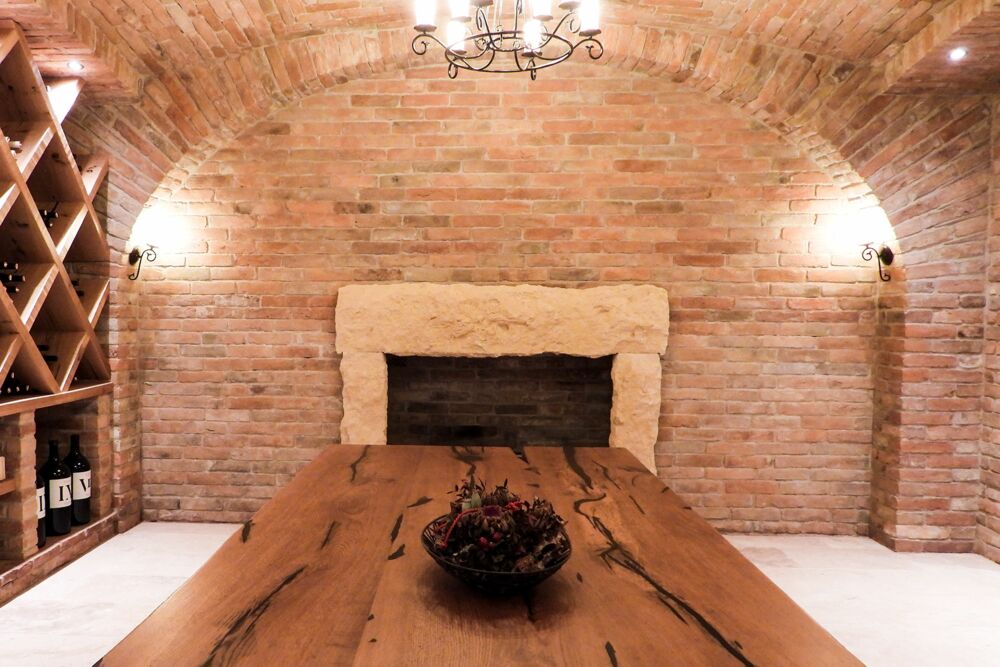 Gewölbesaal gemauert aus Ziegel mit großer Holztafel und offenem Kamin