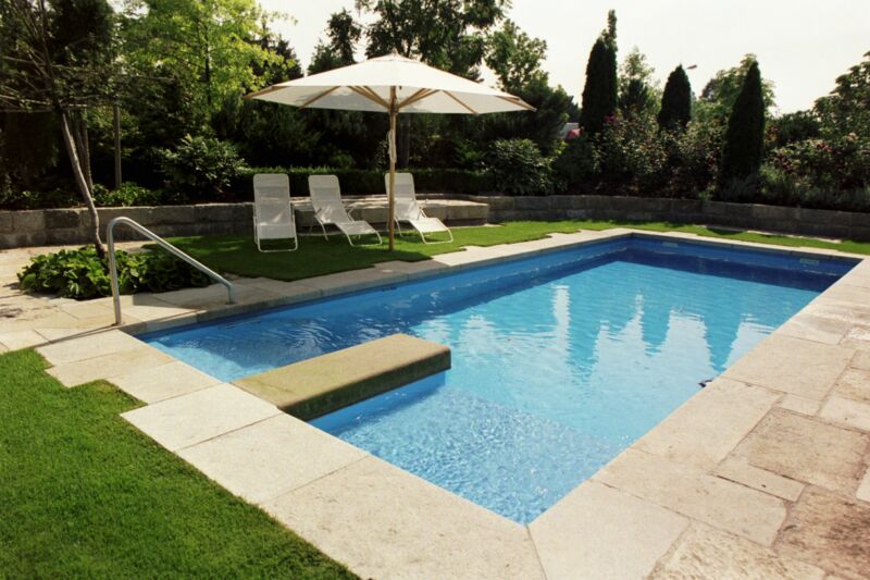 Outdoor-Pool und Liegebereich mit handverlegten Steinplatten im römischen Verband