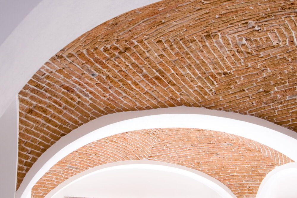 Dezent gestaltet und verputzte Gurtbögen im Geschäftsraum mit Gewölbe